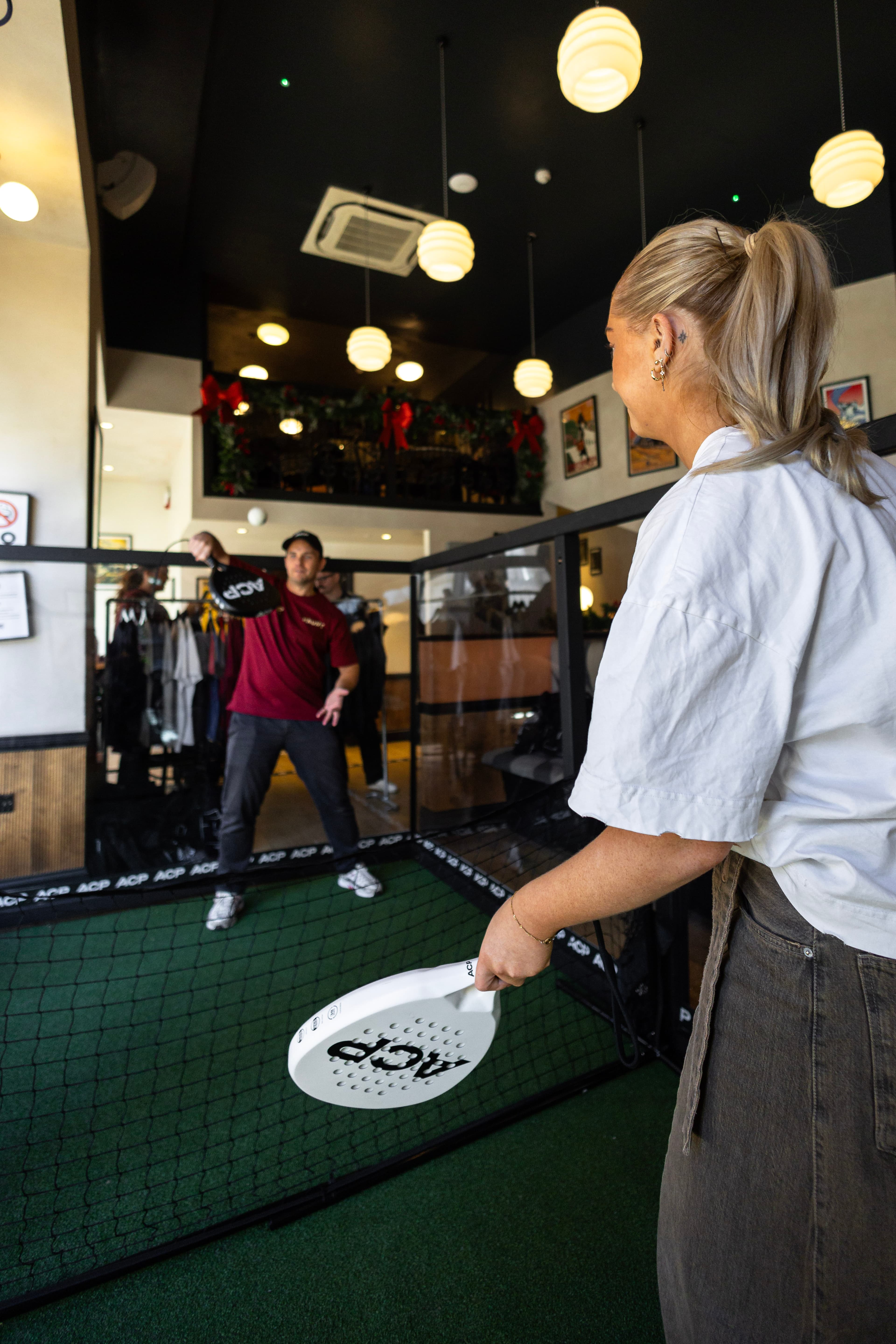 Wide overhead shot of the Haunt venue with the padel court in full swing